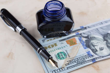 Fountain Pen on old paper with dollar banknotesの写真素材