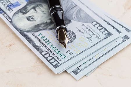 Fountain Pen on old paper with dollar banknotesの写真素材