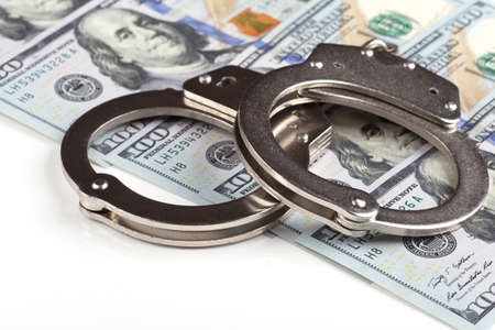 handcuffs on dollar banknotes background