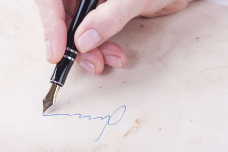 A female hand signs of the old fountain penの写真素材