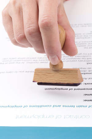 female hand puts a stamp in the employment contract