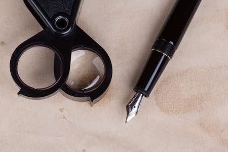 magnifying glass and fountain pen over old paperの写真素材