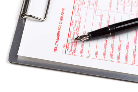 health insurance claim form on the clipboard with pen