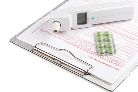 health insurance claim form with thermometer and pills