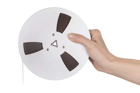 Female hand holding Tape of reel tape recorder over whiteの写真素材