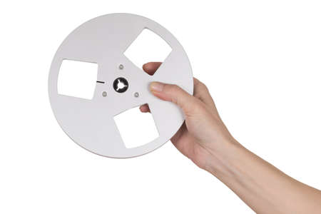 Female hand holding empty reel of tape recorder over whiteの写真素材