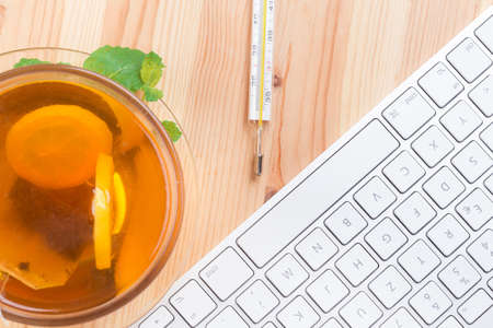 Lemon Tea with mercury thermometer and computer keyboardの写真素材