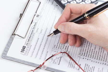 female hand filling out Income Tax Return Formの写真素材