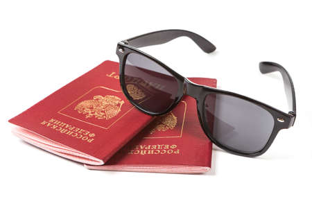 russian passports and sunglasses over whiteの写真素材
