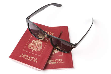 russian passports and sunglasses over whiteの写真素材