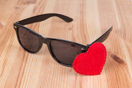 sunglasses wayfarer with heart symbol over wooden backgroundの写真素材