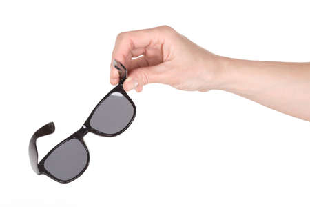 Female hand holding sunglasses over whiteの写真素材