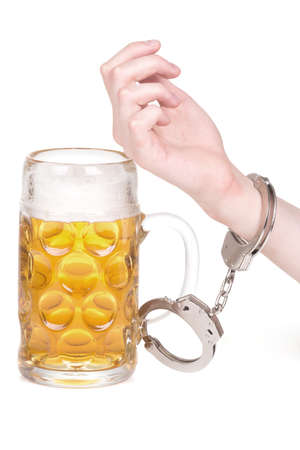 hand handcuffed to a beer mug over whiteの写真素材
