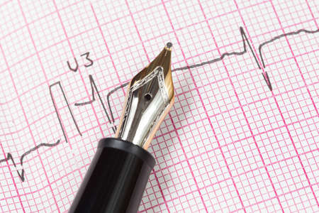 Old Fountain Pen on cardiogram close-up