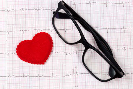 glasses on the electrocardiogram with heart の写真素材