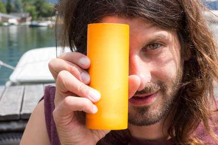 young man holding a can and lookin at camera