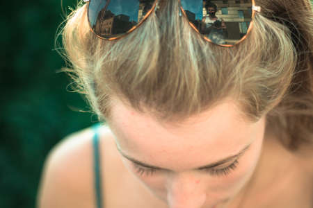 Young woman with sunglasses in her hairの写真素材