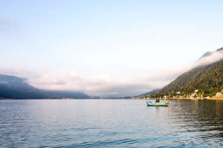 Fisherman on a lake at dawnの写真素材