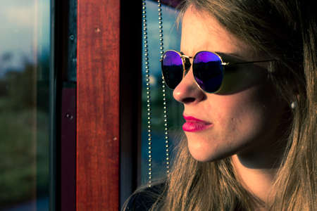 young woman riding the train at sunsetの写真素材