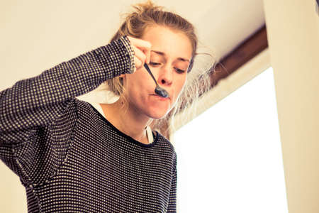 young woman with a spoon eating cerealsの写真素材