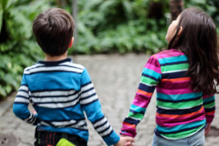 Children holding hands while strollingの写真素材