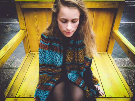 young woman on a huge wooden chair