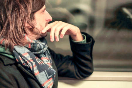 thoughtful man riding the subway in autumnの写真素材