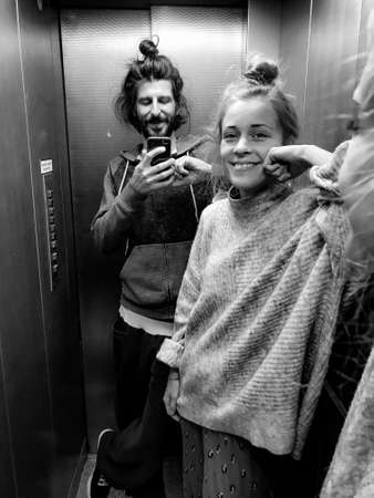 happy couple taking a selfie in elevatorの写真素材