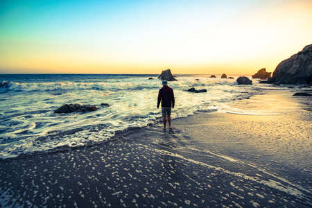 Young man standing on the beach in californiaの写真素材