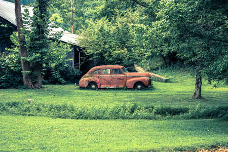 rusty old timer car in natureの写真素材