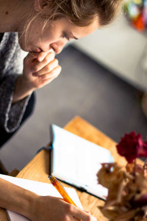 young woman writing a note on paperの写真素材