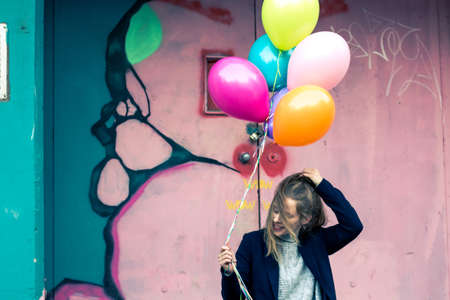 girl holding balloons at abandoned industrial areaの写真素材
