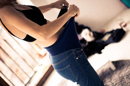 girl showing her pregnant bellyの写真素材