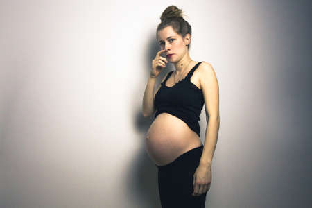 beautiful pregnant young woman posing in lingerie and showing her belly