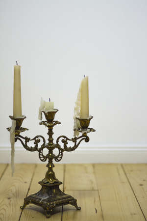 golden vintage candle holder on hardwood floorの写真素材