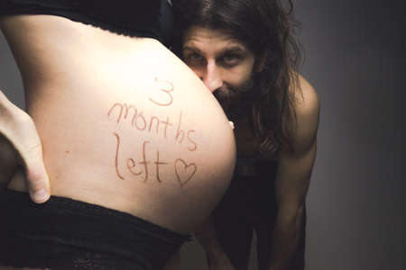 pregnant young woman and her handsome boyfriend counting the days, 3 months leftの写真素材