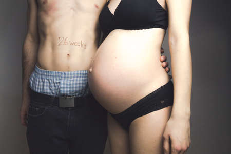 pregnant young woman and her handsome boyfriend counting the days, 26 weeks