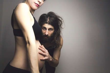 beautiful pregnant woman and her handsome boyfriend posing in lingerieの写真素材