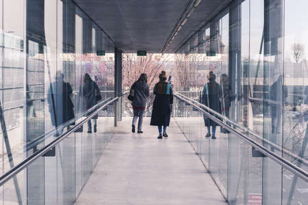 two women walking in a tunnel made of glass