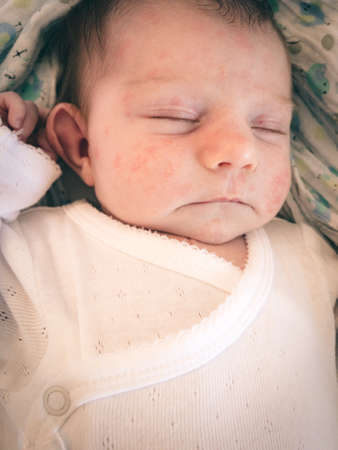newborn baby listening with an open ear while sleeping