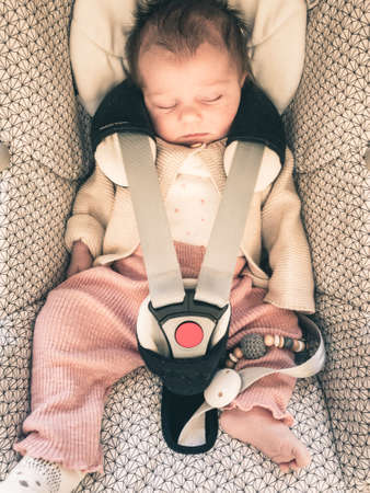 infant baby sleeping in car with seatbelt onの写真素材