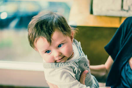 beautiful baby toddler with long hair wearing dungareesの写真素材
