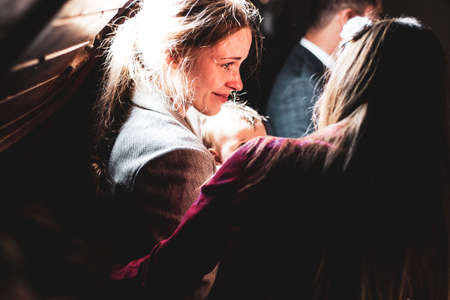 mother crying and holding her baby in the darkの写真素材