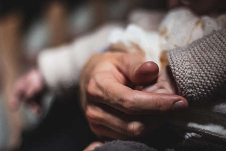 parenthood - holding a babies hand to give safety