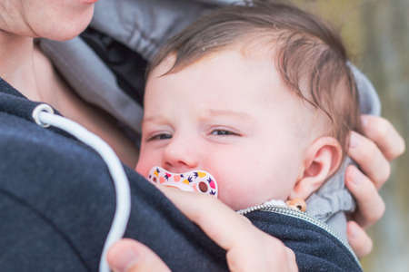 tired baby in baby carrier