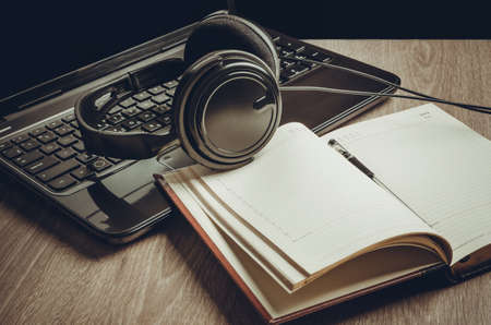 laptop with headphones and notebook on the tableの写真素材