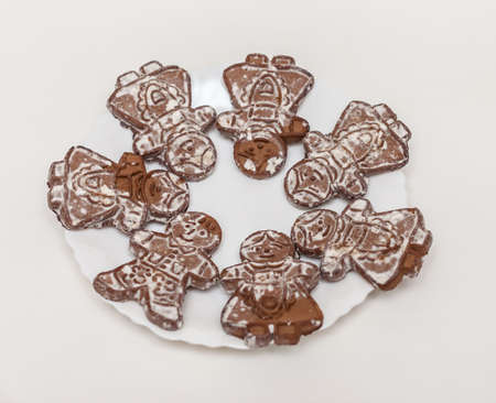 White plate with ginger cookies in the shape of little men on a white backgroundの写真素材