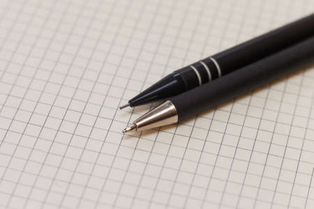 Black ballpoint pen and clutch pencil on paperの写真素材