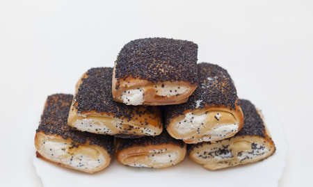 butter cookies with filling and poppy seeds on a white plate on a white backgroundの写真素材