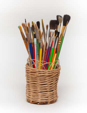 Colorful artistic brushes in a wicker basketの写真素材